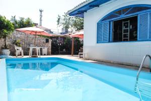 a swimming pool in front of a house at World Hostel - Canasvieiras in Florianópolis