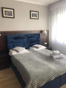 a bedroom with a large bed with two towels on it at Apartamenty w Arka Medical Spa in Kołobrzeg
