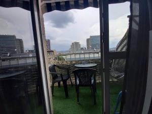 balcón con vistas a una mesa y sillas en Nino Duplex Apartment, en Tiflis