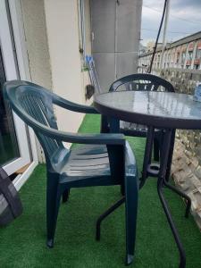 2 sillas y una mesa en el balcón en Nino Duplex Apartment, en Tiflis