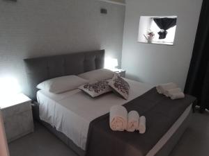 a bedroom with a bed with two slippers on it at Lilly house in Catania