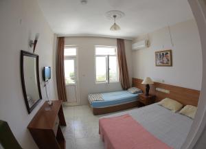 Habitación de hotel con cama y espejo en Mavi Cennet Camping&Pansiyon, en Kızılot