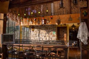 a bar in a restaurant with a wooden table and chairs at La Escondida Hotel Boutique in Zacatlán