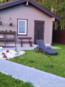 a picnic table and a bench in front of a house at Poilsio namelis Nemirseta in Palanga