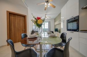グジラにあるAzure Haven - Gzira Apartments and Penthouse By ShortLetsMaltaのテーブルと椅子のあるキッチンとダイニングルーム +38枚の写真