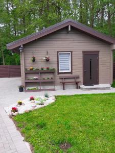 a small shed with a bench in a yard at Poilsio namelis Nemirseta in Palanga