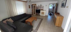 a living room with a black couch and a table at Apartment Hüttner in Gmunden