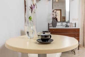a white table with a glass vase and two cups at Kallisti Studios in Naxos Chora +209 photos