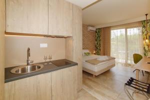 a kitchen with a sink and a bed in a room at The Archontariki in Ormos Panagias