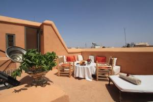 a patio with a table and chairs on a roof at Riad Dar Aicha en Exclusivité in Marrakesh