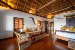 un soggiorno con un letto e un divano di Turtle Inn by Francis Ford Coppola a Placencia