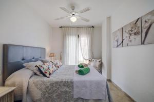 马尼尔瓦Apartamento 409 Marina Real Puerto de la Duquesa playa的带床和吊扇的卧室 更多56张照片