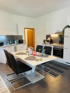 - une cuisine avec une table et des chaises dans la chambre dans l'établissement Ferienwohnung Marina an der Romantischen Straße, à Weikersheim