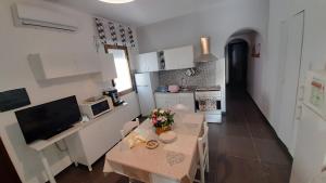 a small kitchen with a small table and a small kitchen with white cabinets at CasaVacanze Le Tre Caravelle in Mazara del Vallo