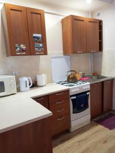 a kitchen with wooden cabinets and a stove top oven at Jaśmin in Budry