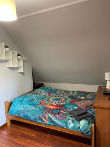um quarto com uma cama com um cobertor colorido em Dom Natura em Zdbice