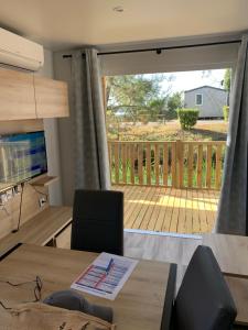 salon ze stołem i dużymi przesuwnymi szklanymi drzwiami w obiekcie Envie d un break de paysages sauvages et de nature ce mobile home neuf tout confort climatise idealement situe au bord de l eau dans un camping 4 etoiles vous attend pour un week end quelques jours ou des vacances en famille w mieście Cap-Ferret