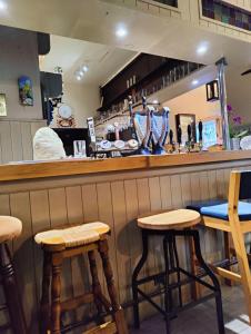 a bar with wooden stools in a restaurant at The Lampet Arms in Banbury
