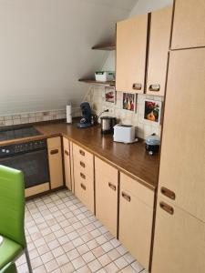 a kitchen with wooden cabinets and a black appliance at Ferienwohnung mit toller Aussicht in Albstadt