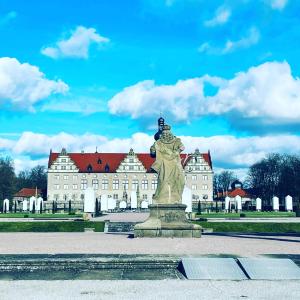 a statue in front of a large building at Ferienwohnung Marina an der Romantischen Straße in Weikersheim +17 photos