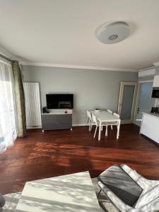 sala de estar con suelo de madera y mesa en The Dante Prague - Family Apartments with FREE PARKING, en Praga