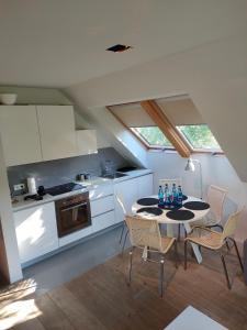 uma cozinha com mesa e cadeiras num quarto em Loft - Dolny Sopot by OneApartments em Sopot