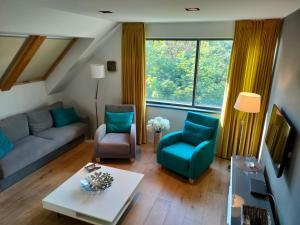 uma sala de estar com um sofá e duas cadeiras em Loft - Dolny Sopot by OneApartments em Sopot