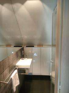 uma casa de banho branca com um lavatório e um chuveiro em Loft - Dolny Sopot by OneApartments em Sopot