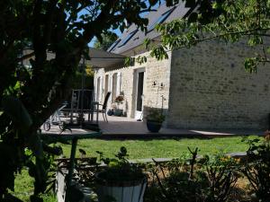 an external view of a house with a patio at Les suites du Doux Refuge in Esquay-sur-Seulles