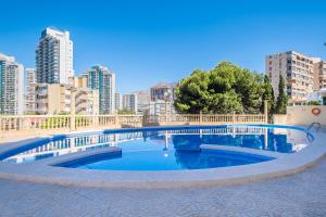 a swimming pool with a city in the background at Atalaya Beach Apartments Sea View in Finestrat