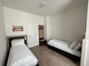 a bedroom with two beds and a couch in it at City Hotel in Schopfheim