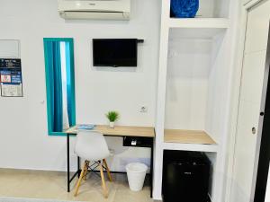 Habitación con escritorio, ordenador y silla. en Dori Rooms Hostal, en Tarifa