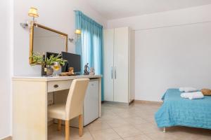 1 dormitorio con escritorio, 1 cama y espejo en Kallisti Studios, en Naxos Chora