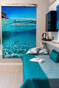 a bedroom with a wall mural of the ocean at Hotel Acquamarina in Portoferraio