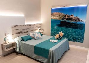 a bedroom with a bed with a painting on the wall at Hotel Acquamarina in Portoferraio