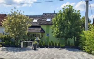 a green house with a courtyard at GRIZZLY apartment for the disabled in Slunj