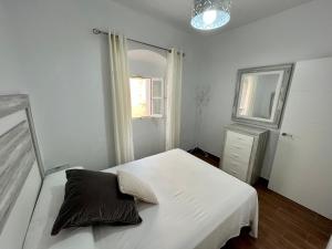 a bedroom with a white bed and a window at APARTAMENTO TARIFA CENTRO in Tarifa
