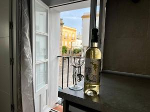 a bottle of wine and a wine glass on a balcony at APARTAMENTO TARIFA CENTRO in Tarifa