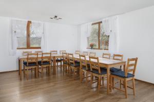 a dining room with a wooden table and chairs at Transylvanian House in Drumu Carului