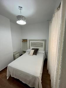 a bedroom with a white bed and a light at APARTAMENTO TARIFA CENTRO in Tarifa