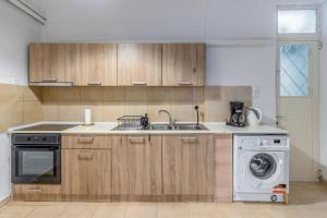 een keuken met een wastafel en een wasmachine bij Apartment 1km from Acropolis Filoppapou Hill in Athene