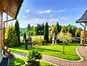 un jardín con césped y un camino en Bajkowe Domki en Polańczyk