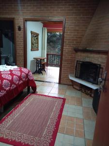 sypialnia z łóżkiem i kominkiem w obiekcie Caminho do Sol w mieście Monte Verde