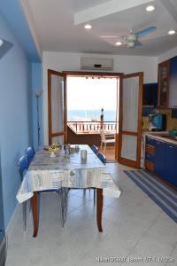 - une salle à manger avec une table et une vue sur l'océan dans l'établissement Le Note del Mare appartamento vista mare, à Roccalumera