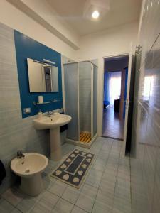 La salle de bains est pourvue d'un lavabo, de toilettes et d'une douche. dans l'établissement Le Note del Mare appartamento vista mare, à Roccalumera