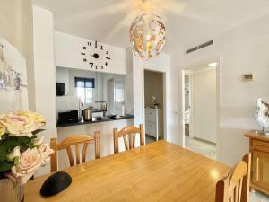 une cuisine et une salle à manger avec une table et une horloge dans l'établissement Casa Luna Golf Beach Torrequebrada Parking FREE, à Benalmádena