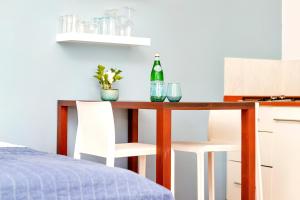 1 dormitorio con mesa, 1 botella y 2 sillas en Kas di Amigu, en Kralendijk