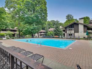 a swimming pool with chairs in front of a building at 335E Mountain Villa in Boyne Falls