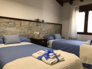 um quarto de hotel com duas camas com toalhas em Casa Rural Las Cigüeñas de Las Navillas em Navas de Ríofrío