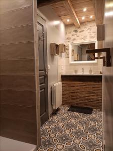 a bathroom with a sink and a counter with a mirror at La grenouille amoureuse in Menat